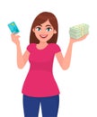 Attractive happy young woman holding or showing a credit/debit card, bundle of cash/money/currency notes in hand. Royalty Free Stock Photo