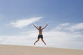 Attractive young woman leaps mid air on summer beach Royalty Free Stock Photo