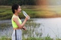Attractive healthy fitness girl drinking water after workout. Runner girl take a rest after training Royalty Free Stock Photo