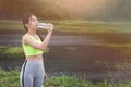 Attractive healthy fitness girl drinking water after workout. Runner girl take a rest after trainning Royalty Free Stock Photo