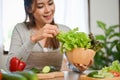 Attractive and healthy Asian female preparing ingredients for her fresh and tasty green salad Royalty Free Stock Photo