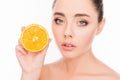 Attractive healthy young woman holding half of orange near her face Royalty Free Stock Photo