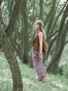 Attractive hippie girl standing among the trees in the forest Royalty Free Stock Photo
