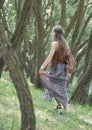 Attractive hippie girl standing among the trees in the forest Royalty Free Stock Photo