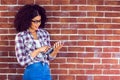 Attractive hipster leaning on wall and using tablet Royalty Free Stock Photo