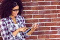 Attractive hipster leaning on wall and using tablet Royalty Free Stock Photo