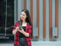 Attractive hipster young woman standing and using mobile phone in city walking street Royalty Free Stock Photo