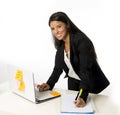 Attractive hispanic businesswoman or secretary taking notes standing leaning on office computer desk Royalty Free Stock Photo