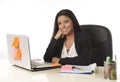 Attractive hispanic businesswoman sitting at office desk working on computer laptop smiling happy Royalty Free Stock Photo