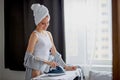 Attractive housewife iron clothes at home