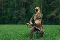 Attractive hunter girl with hunting carbine looking into binoculars