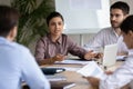 Attractive indian ethnic businesswoman with businessman partner talking in boardroom.