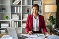 Attractive and inspired Asian businesswoman sits at her desk, looking out the window Royalty Free Stock Photo