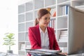 Attractive and inspired asian businesswoman sits at her desk, looking out the window, and daydreaming about her career Royalty Free Stock Photo