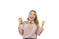 Attractive and joyful blonde girl in a shirt is standing sideways and looking at the phone in her hand looking at the Royalty Free Stock Photo