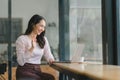 The attractive and joyful millennial Indian freelancer woman is using a laptop computer to video chat and waving at