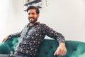 Attractive Latin American man resting on his green sofa in home office Royalty Free Stock Photo