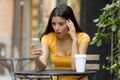 Attractive latin woman shocked on her smart phone Royalty Free Stock Photo