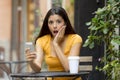 Attractive latin woman shocked on her smart phone Royalty Free Stock Photo