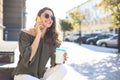 Attractive laughing woman talking on cellphone while sitting in stairs outdoors