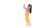 Attractive little Asian child girl in pink-yellow dungarees with headphones to enjoys listening music by smartphone isolated on Royalty Free Stock Photo