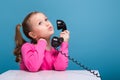 Attractive little cute girl in pink shirt with monkey and blue trousers hold empty poster and talks a phone Royalty Free Stock Photo