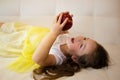Attractive little girl is holding a red apple in her hand