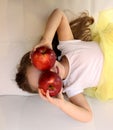 Attractive little girl is holding a red two apple in her hand Royalty Free Stock Photo