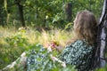 Attractive girl in the forest in a dress sits under a tree in the grass Royalty Free Stock Photo