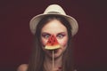 Attractive Lovely girl with pink make up, wearing jeans, hat and top, posing at red studio background, holding slice watermelon Royalty Free Stock Photo