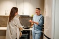 Attractive loving couple having fun in the kitchen. Handsome man juggle with apples to impress his girlfriend Royalty Free Stock Photo