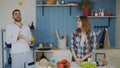 Attractive loving couple having fun in the kitchen. Handsome man juggle with fruits to impress his girlfriend