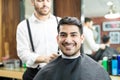 Customer Smiling While Barber Adjusting Hairdressing Cape On Him