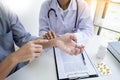 Attractive Male doctor Examining discussing reports with Massage patient suffering from back pain in clinic Royalty Free Stock Photo