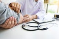 Attractive Male doctor Examining discussing reports with Massage patient suffering from back pain clinic Royalty Free Stock Photo