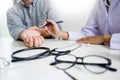 Attractive Male doctor Examining discussing reports with Massage patient suffering from back pain in clinic. Royalty Free Stock Photo