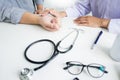 Attractive Male doctor Examining discussing reports with Massage patient suffering from back pain in clinic. Royalty Free Stock Photo