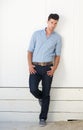 Attractive male fashion model standing against white wall outdoors Royalty Free Stock Photo