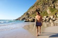 Attractive male surfer walking on beach with surfboard Royalty Free Stock Photo