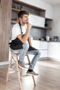 Attractive man with an apple sitting in a home kitchen Royalty Free Stock Photo