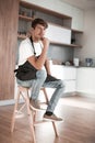 Attractive man with an apple sitting in a home kitchen Royalty Free Stock Photo