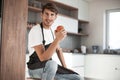 Attractive man with an apple sitting in a home kitchen Royalty Free Stock Photo