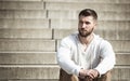 Attractive man with beard is sitting on steps