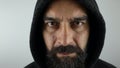 Attractive man with beard wearing black hoodie with seroius face looking at the camera.
