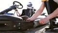 Attractive man checking tire pressure on his gocart