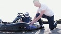 Attractive man checking tire pressure on his gocart