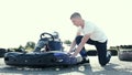 Attractive man checking tire pressure on his gocart