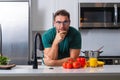 Attractive man cooking in modern kitchen. Handsome man cooking at home preparing salad in kitchen. Casual man preparing Royalty Free Stock Photo