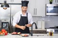 Attractive man cooking in modern kitchen. Handsome man cooking at home preparing salad in kitchen. Casual man preparing Royalty Free Stock Photo