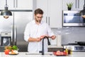 Attractive man cooking in modern kitchen. Handsome man cooking at home preparing salad in kitchen. Casual man preparing Royalty Free Stock Photo